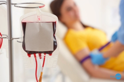 Bolsa de sangue em equipamento de transfusão, com uma pessoa recebendo o procedimento ao fundo. No canto inferior direito, destaca-se o logotipo azul 'Espnet'